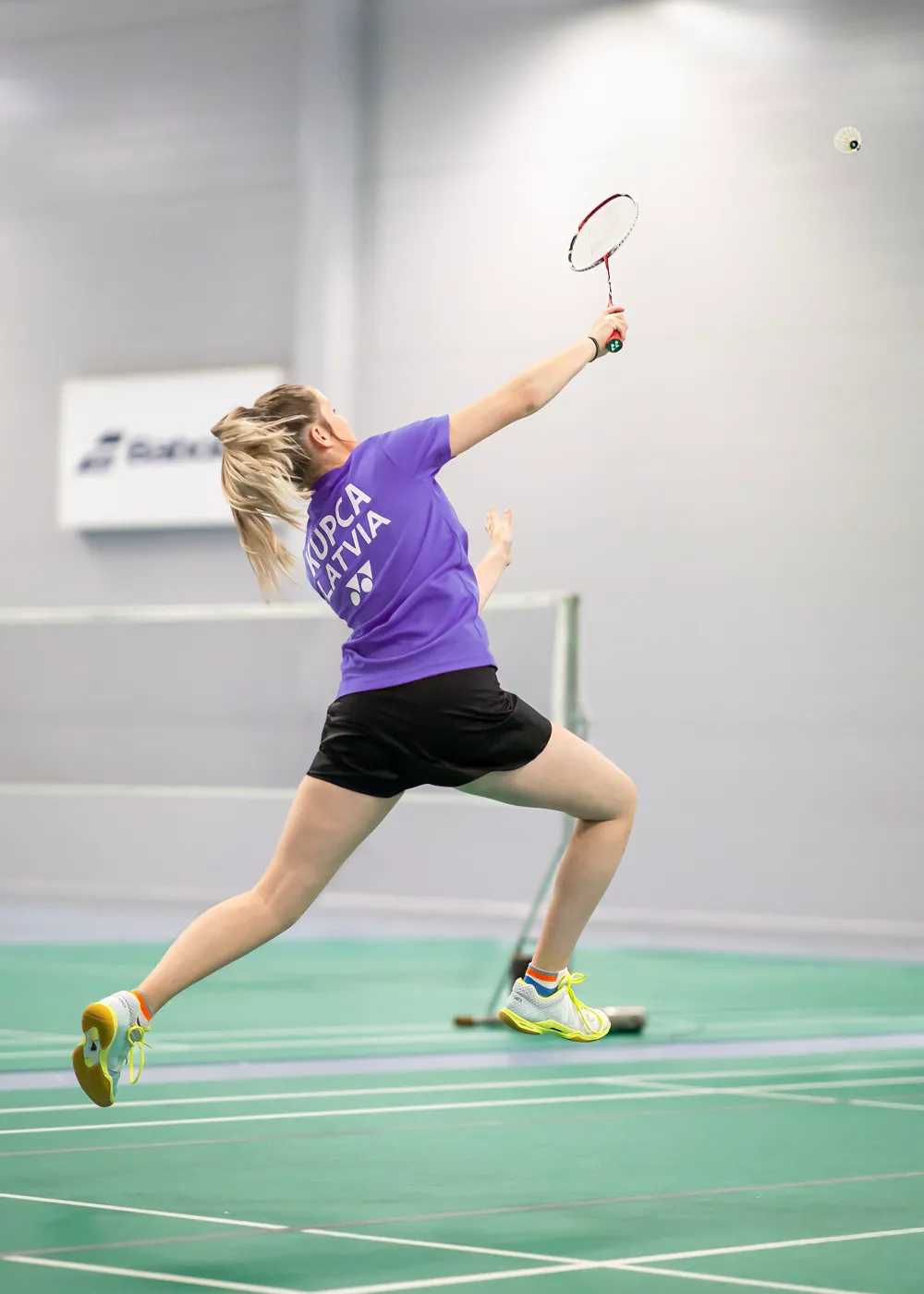 Badminton player reaching for a shot